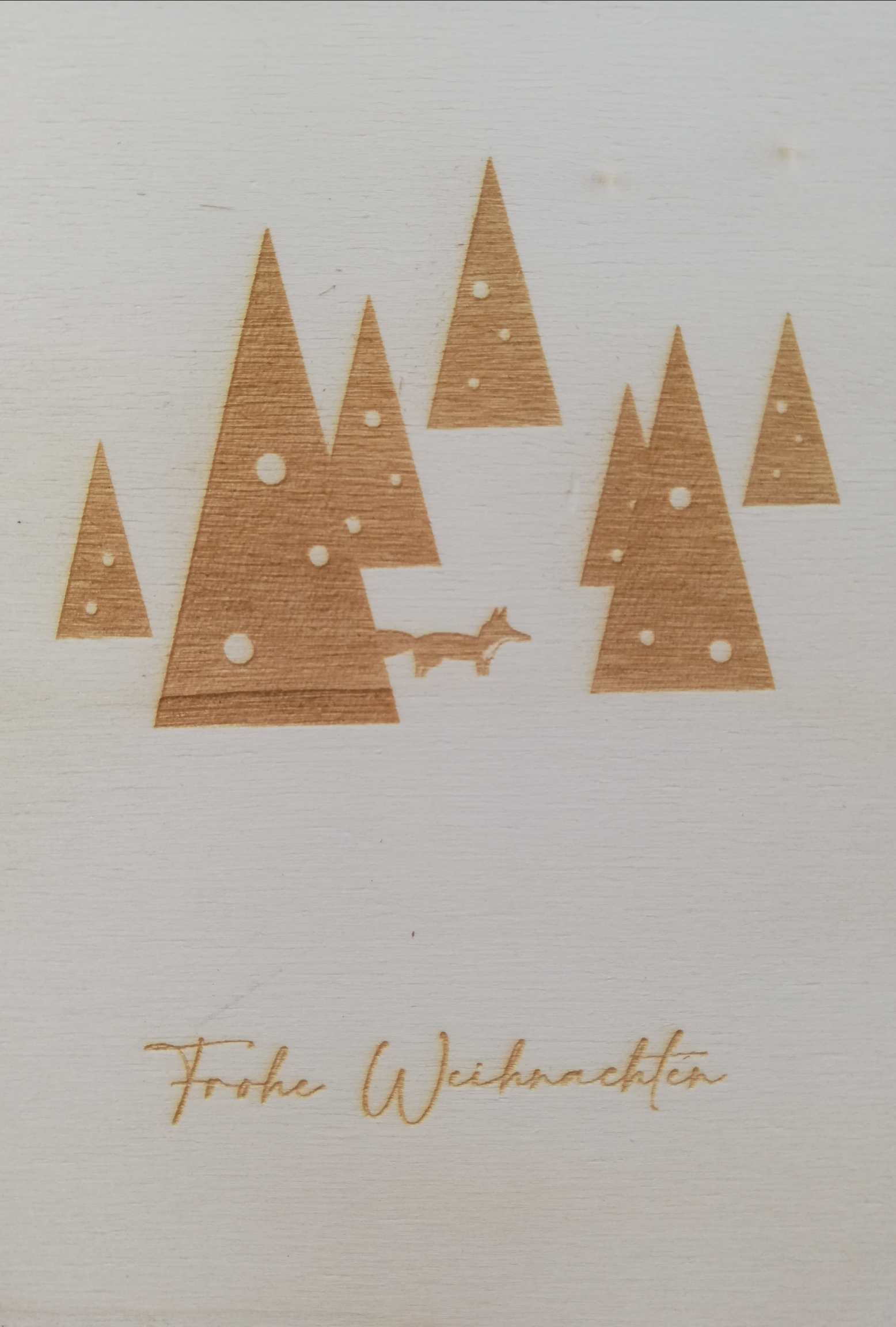 a white and brown card with trees and a fox