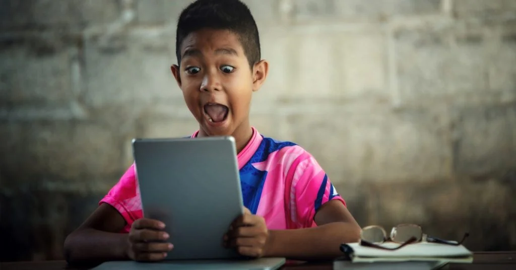 a boy looking at a tablet