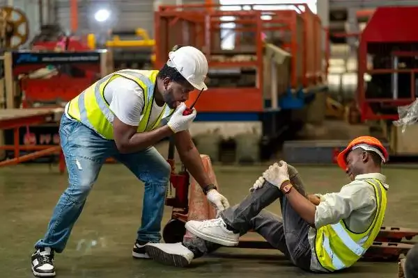 a man in a safety vest and helmet holding a man's leg