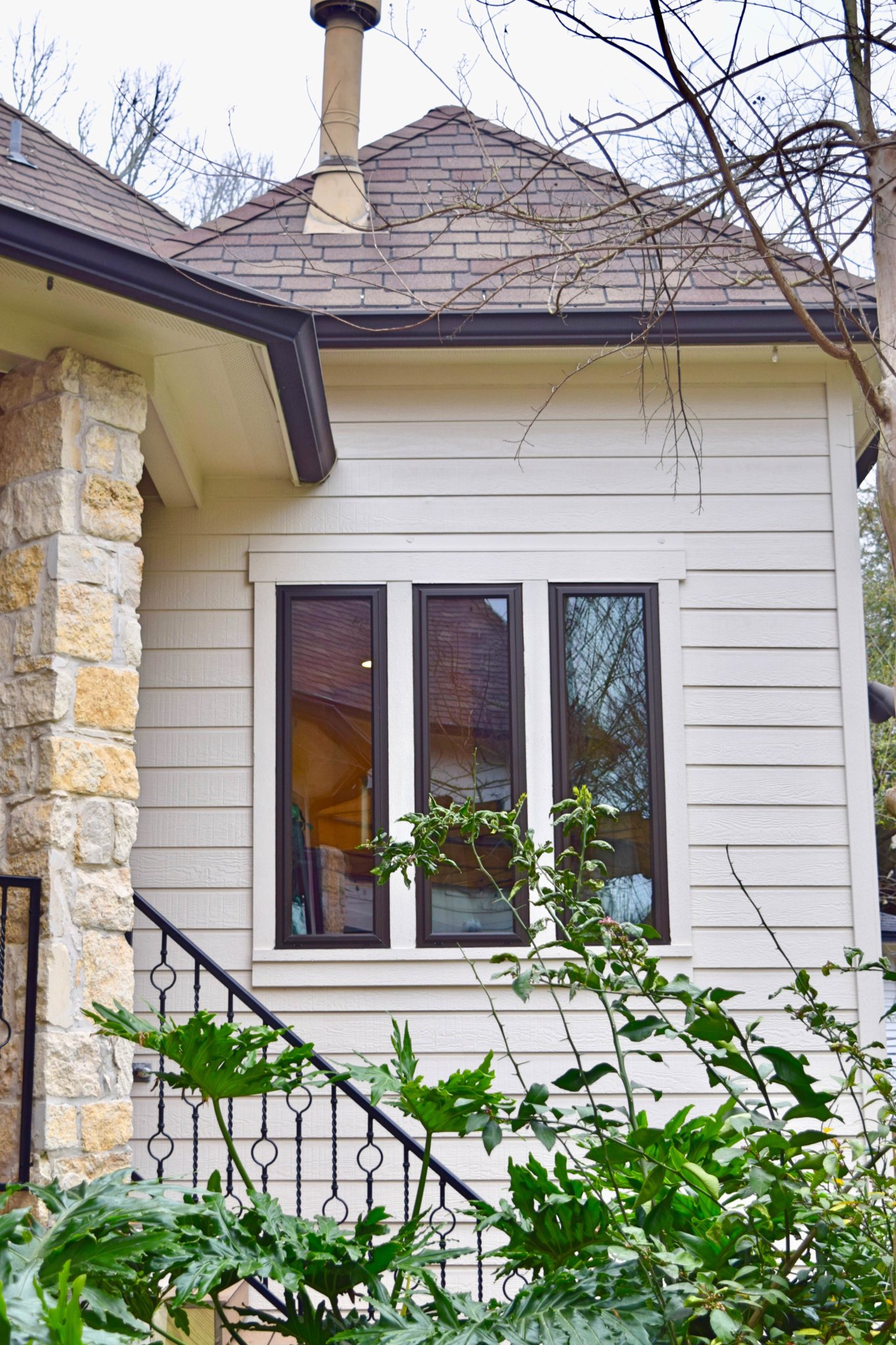 a house with a stone wall and a stone column