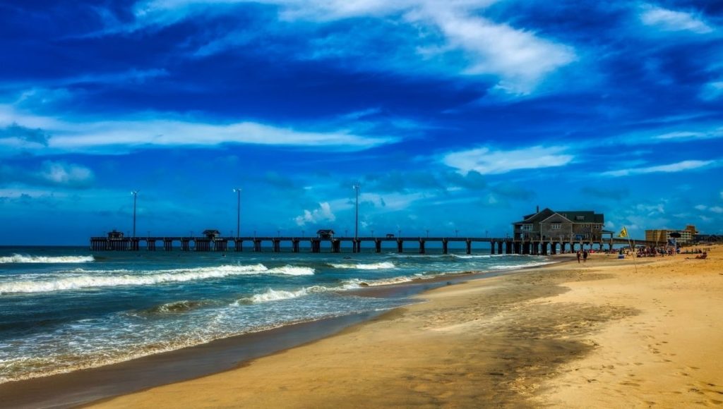 a beach with a pier and a building