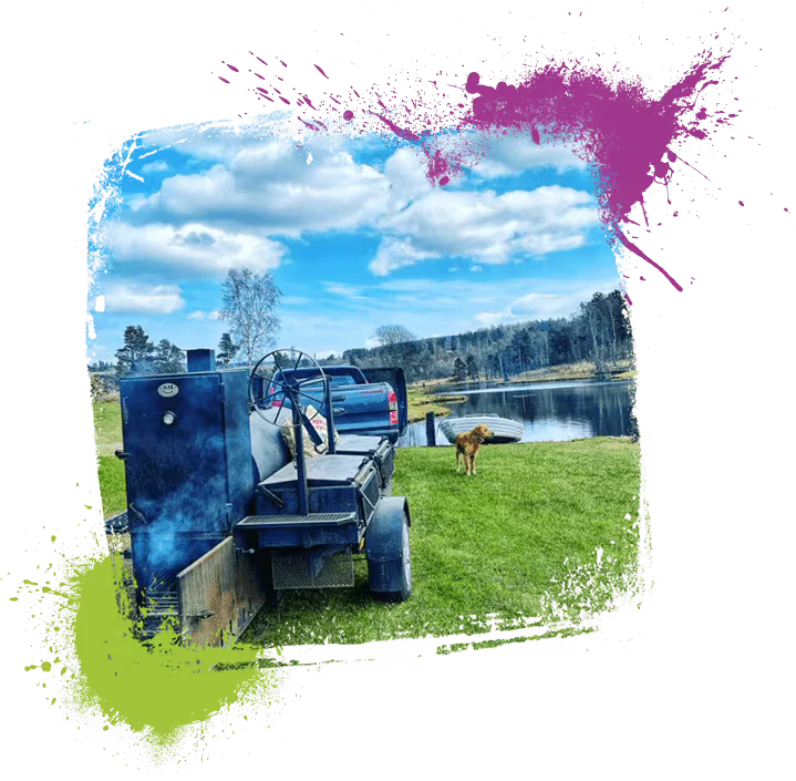 a dog standing in grass next to a tractor