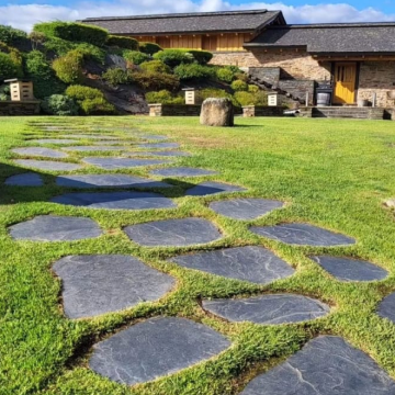 a stone path in a grassy area