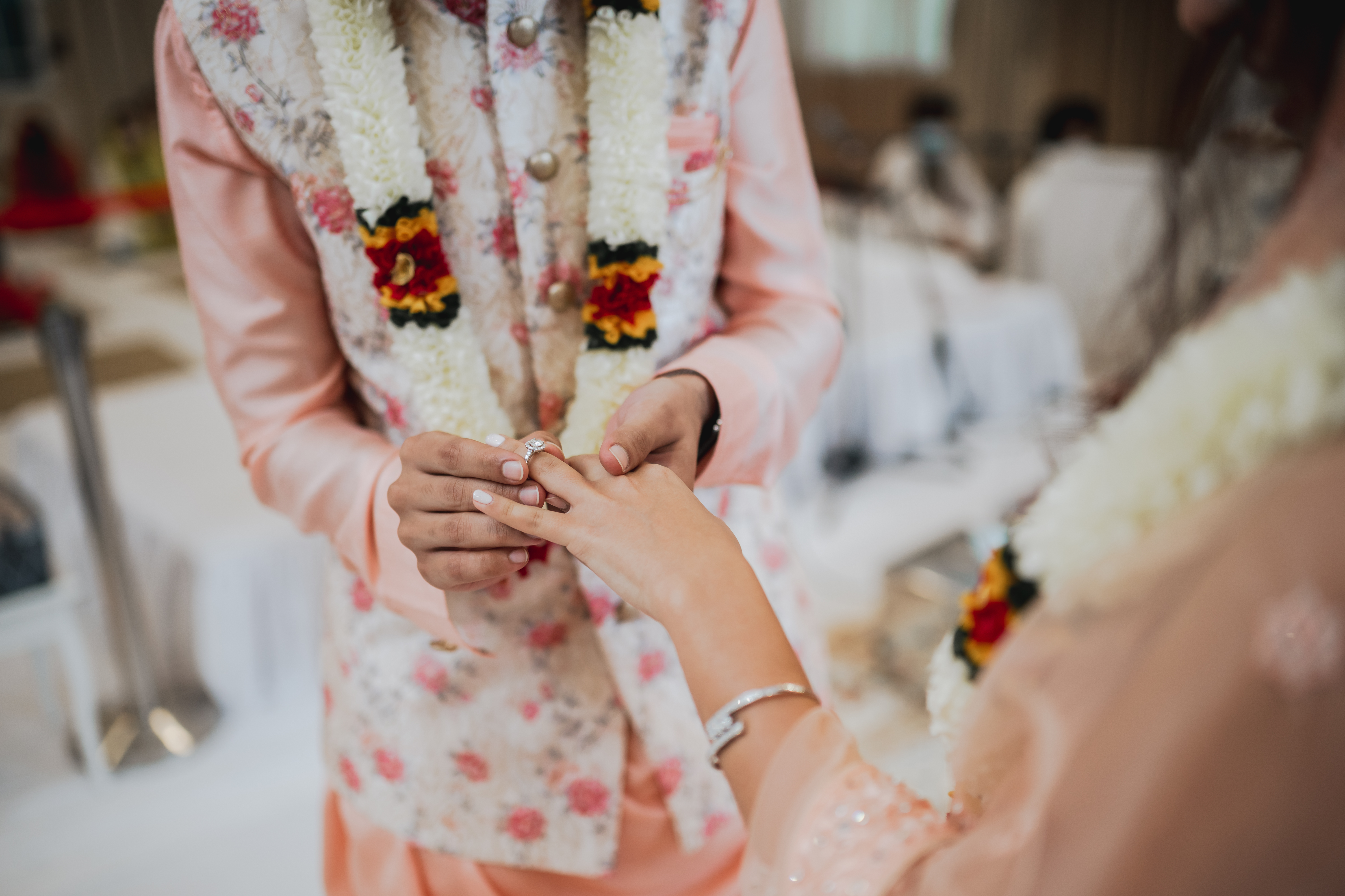 a person putting a ring on another person's hand