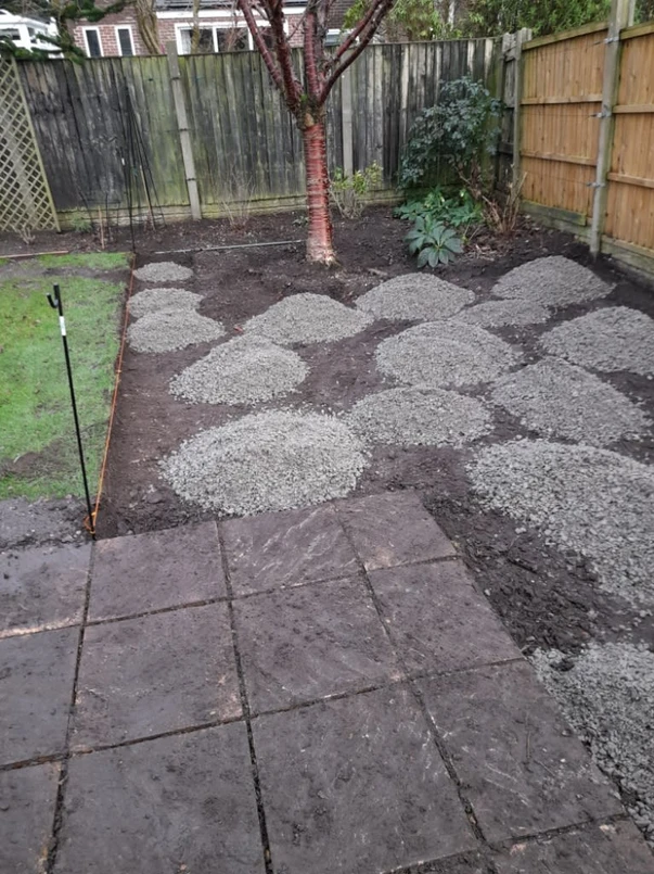 a yard with gravel and a tree