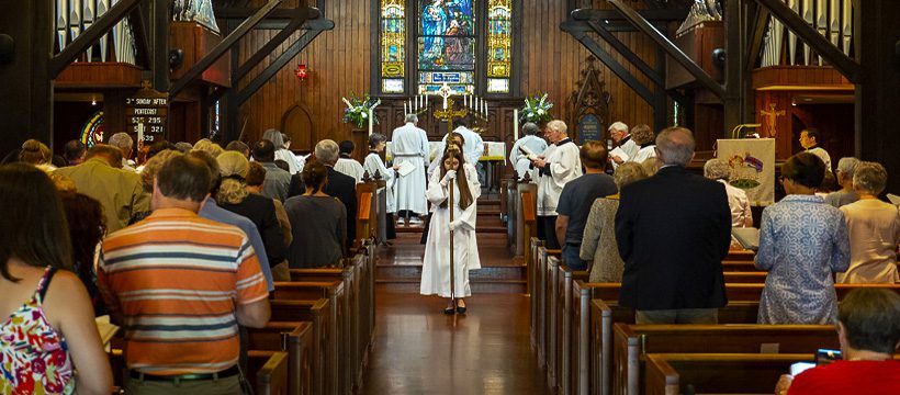 a girl in white robes standing in a church