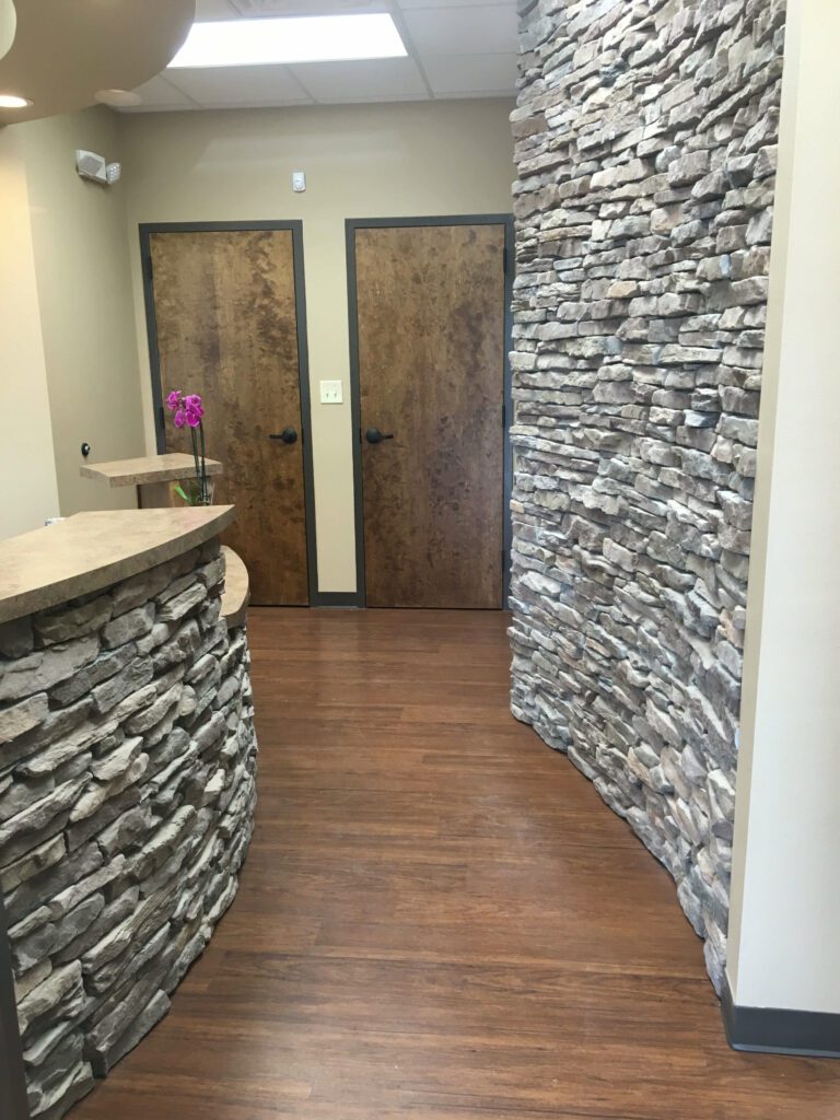 a stone wall with a door and a wood floor