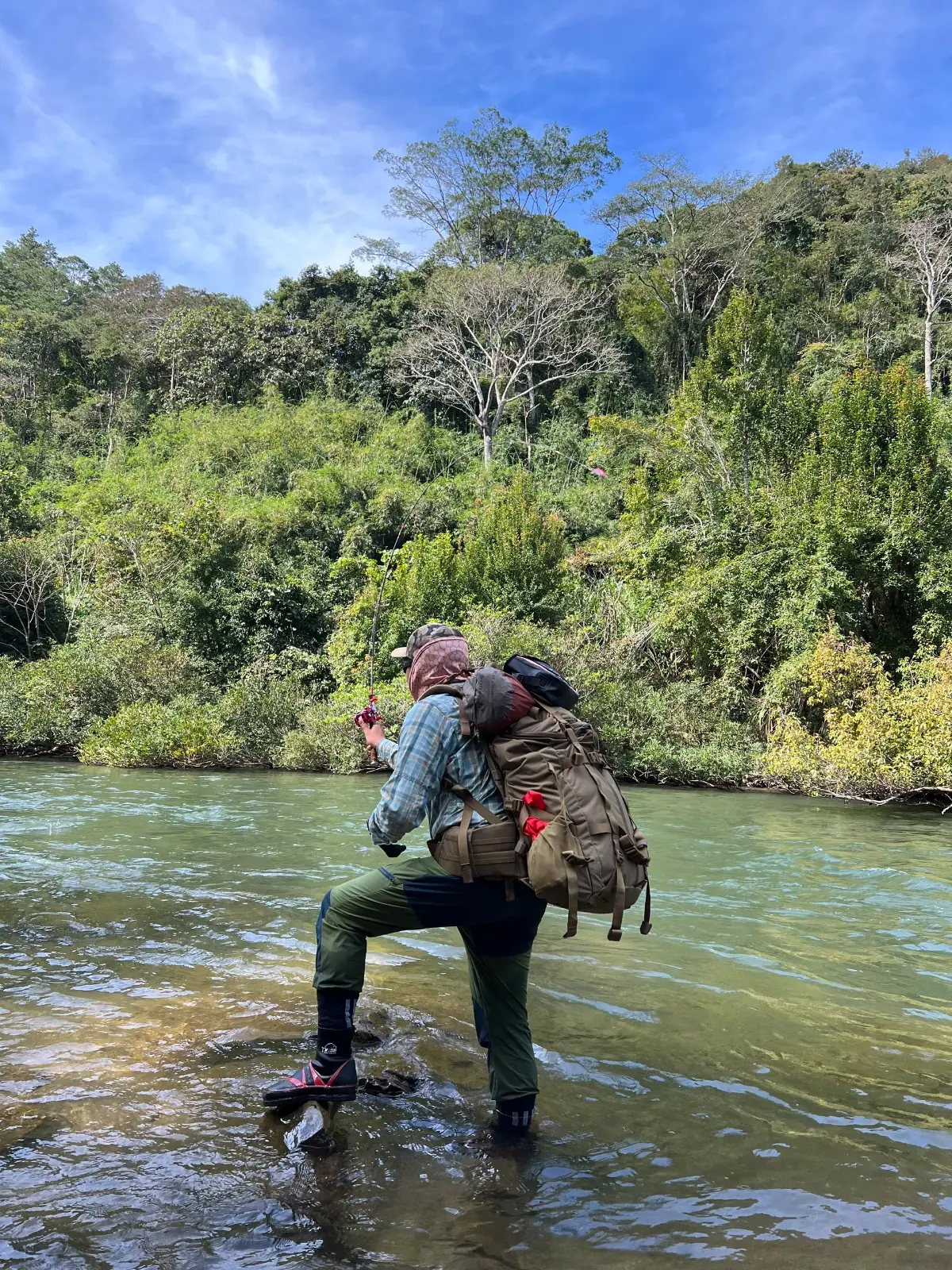 a person standing in a river with a backpack