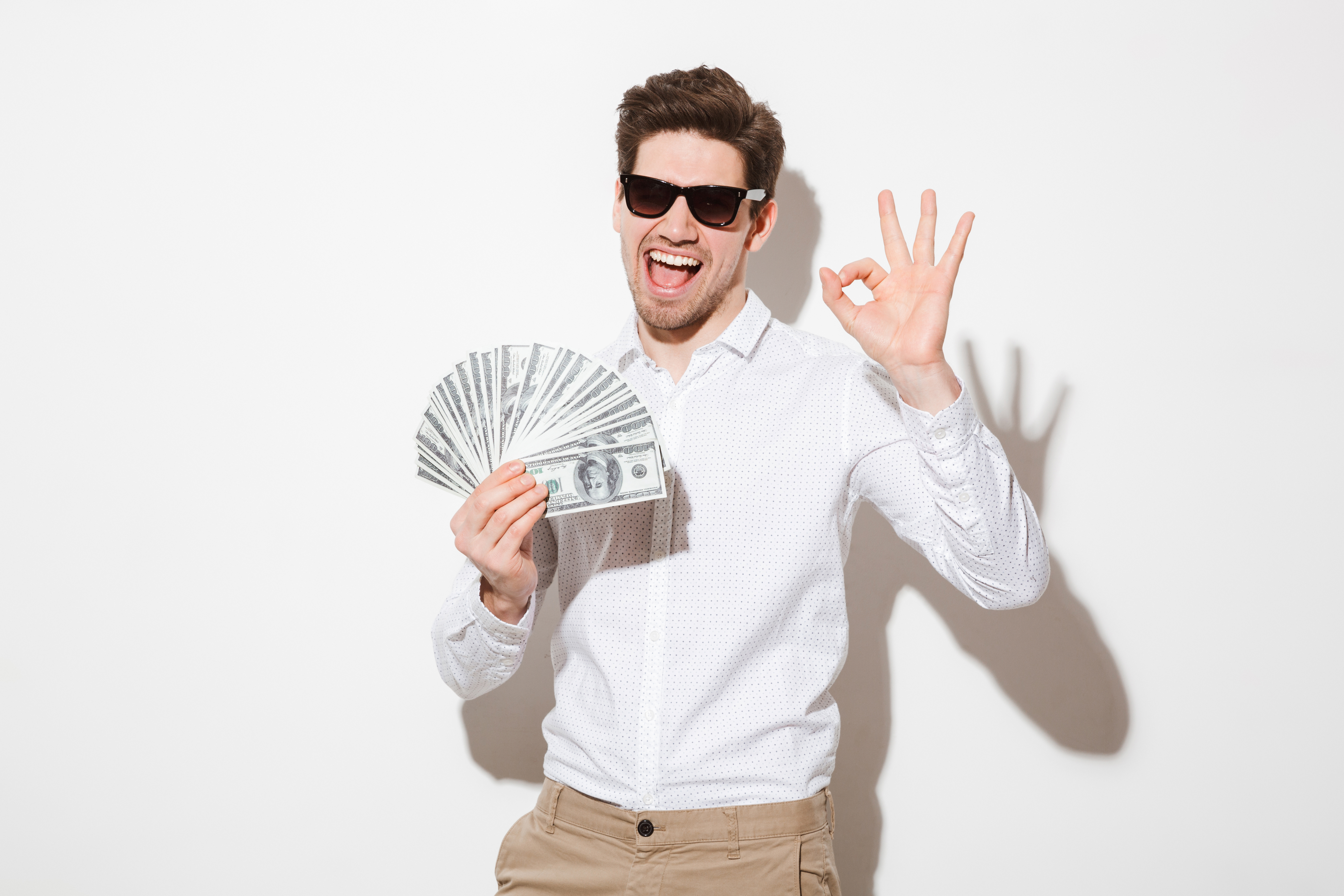 a man holding money and making a hand gesture