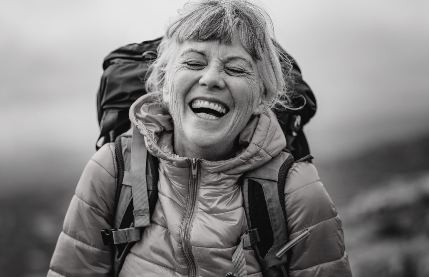 a woman with a backpack laughing