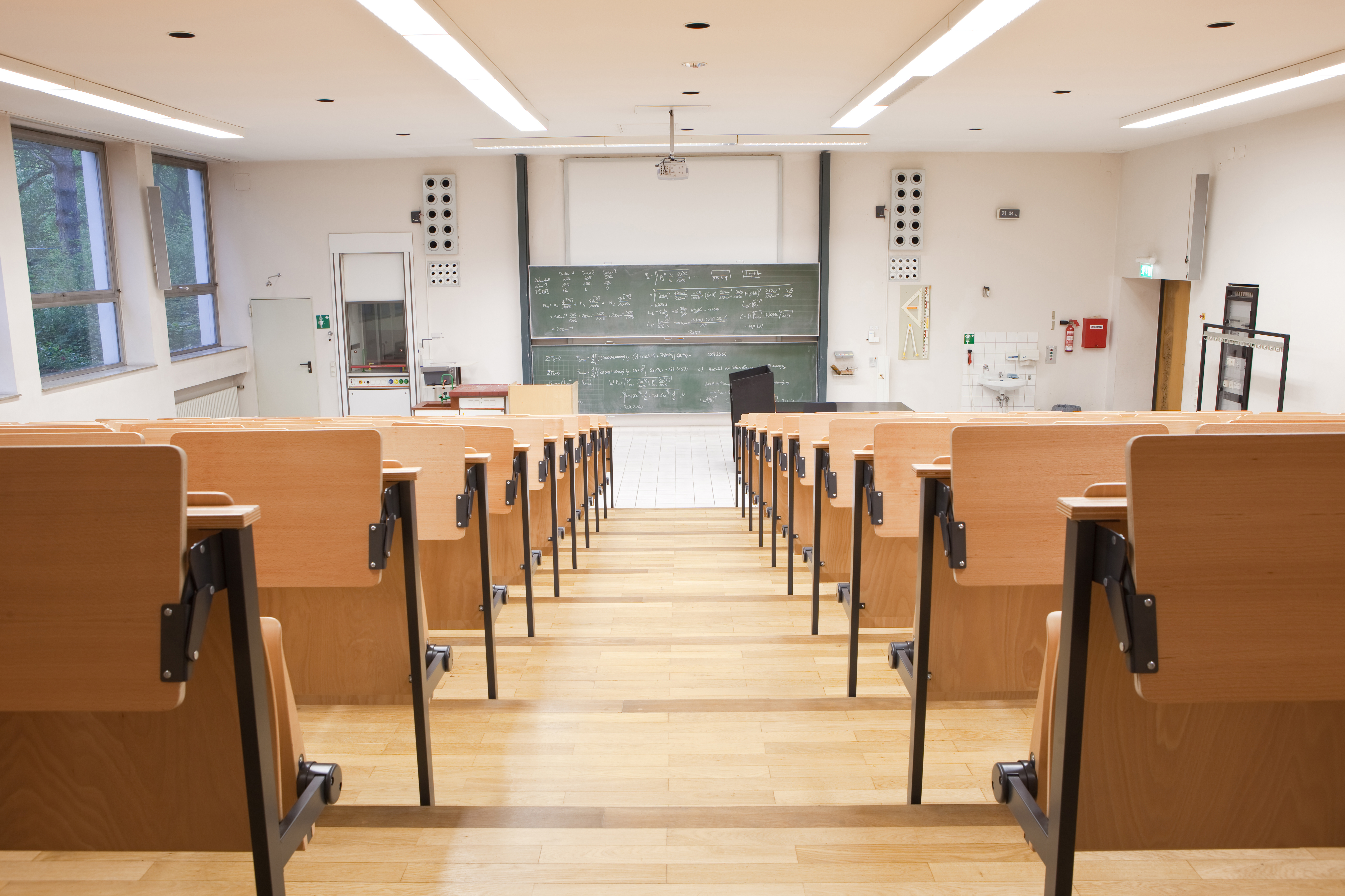 a classroom with wooden chairs and a chalkboard