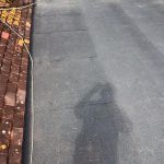 a shadow of a person on the pavement