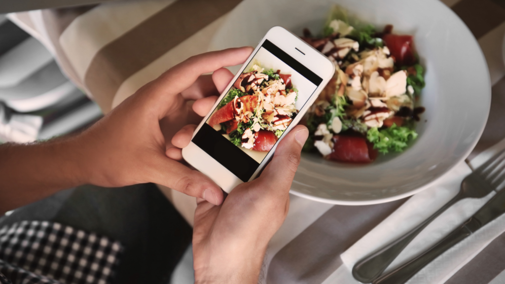 a person holding a phone with a picture of food on it