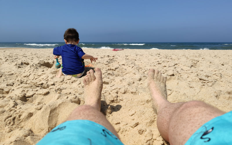 a person's legs and feet on a beach