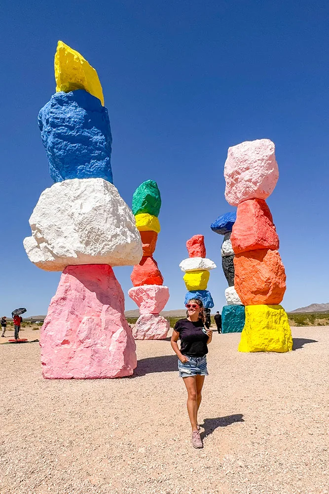 a woman standing in front of colorful stacked rocks
