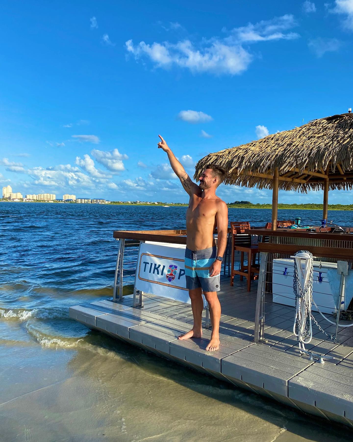 a man standing on a dock with his arm raised