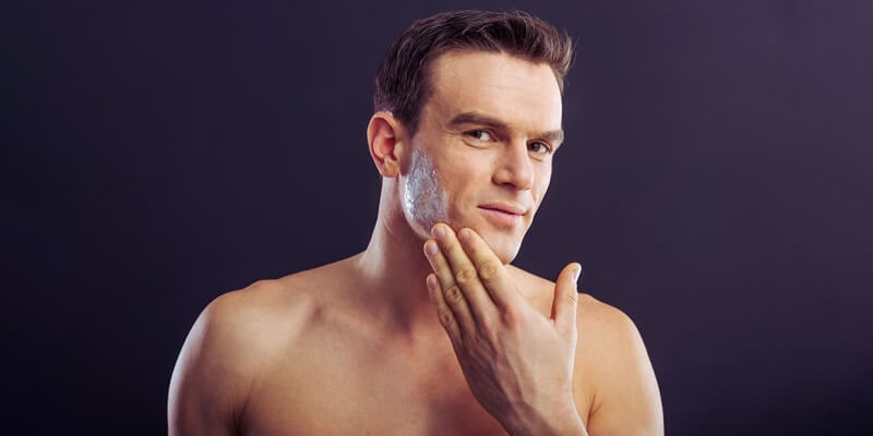 a man applying cream on his face