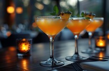 a group of glasses with orange liquid