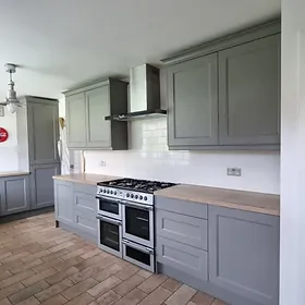 a kitchen with grey cabinets and stoves