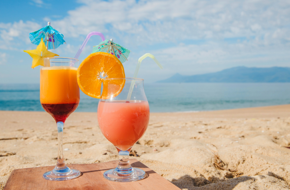 two glasses with drinks on a beach