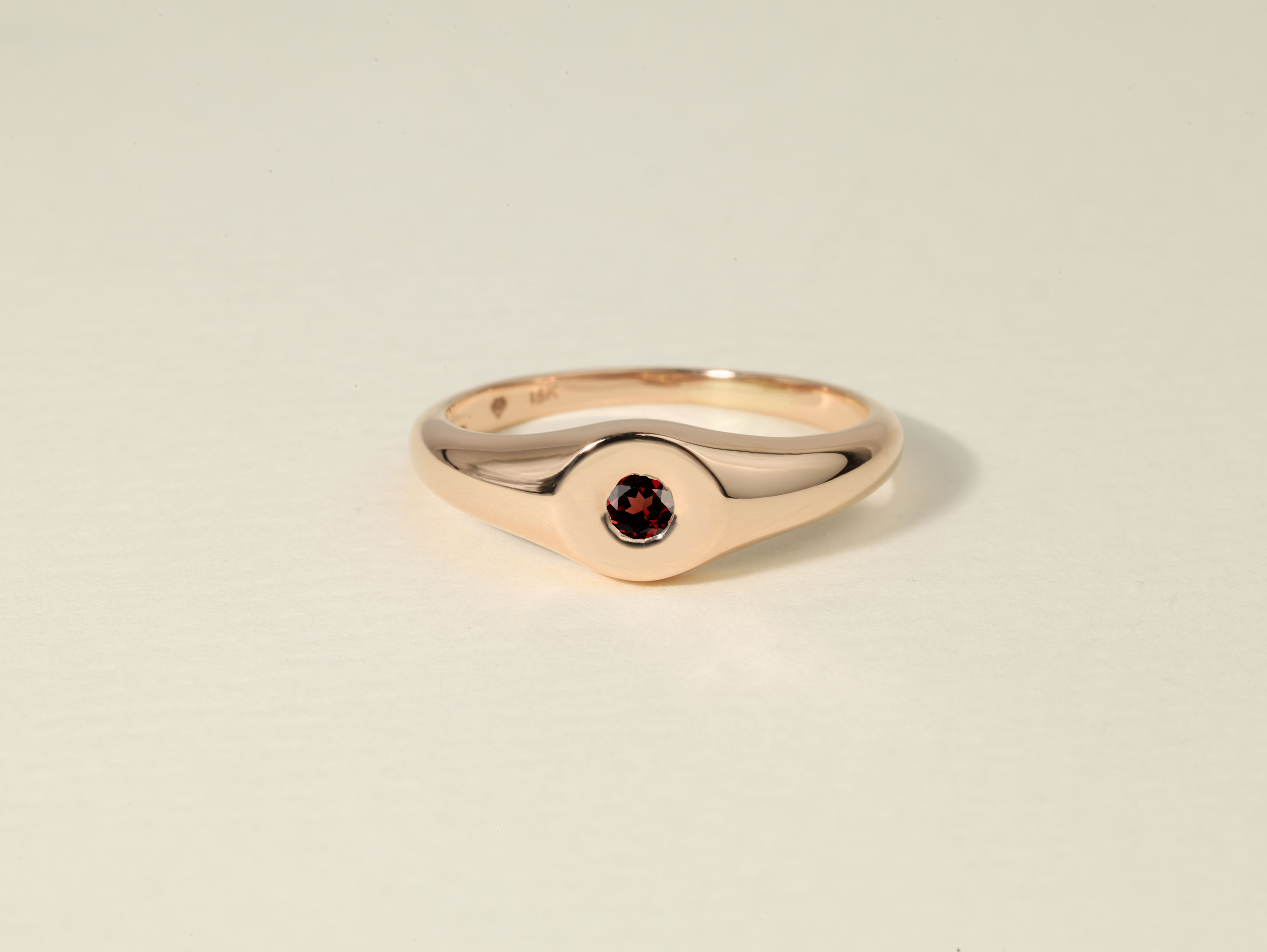 a gold ring with a red gem