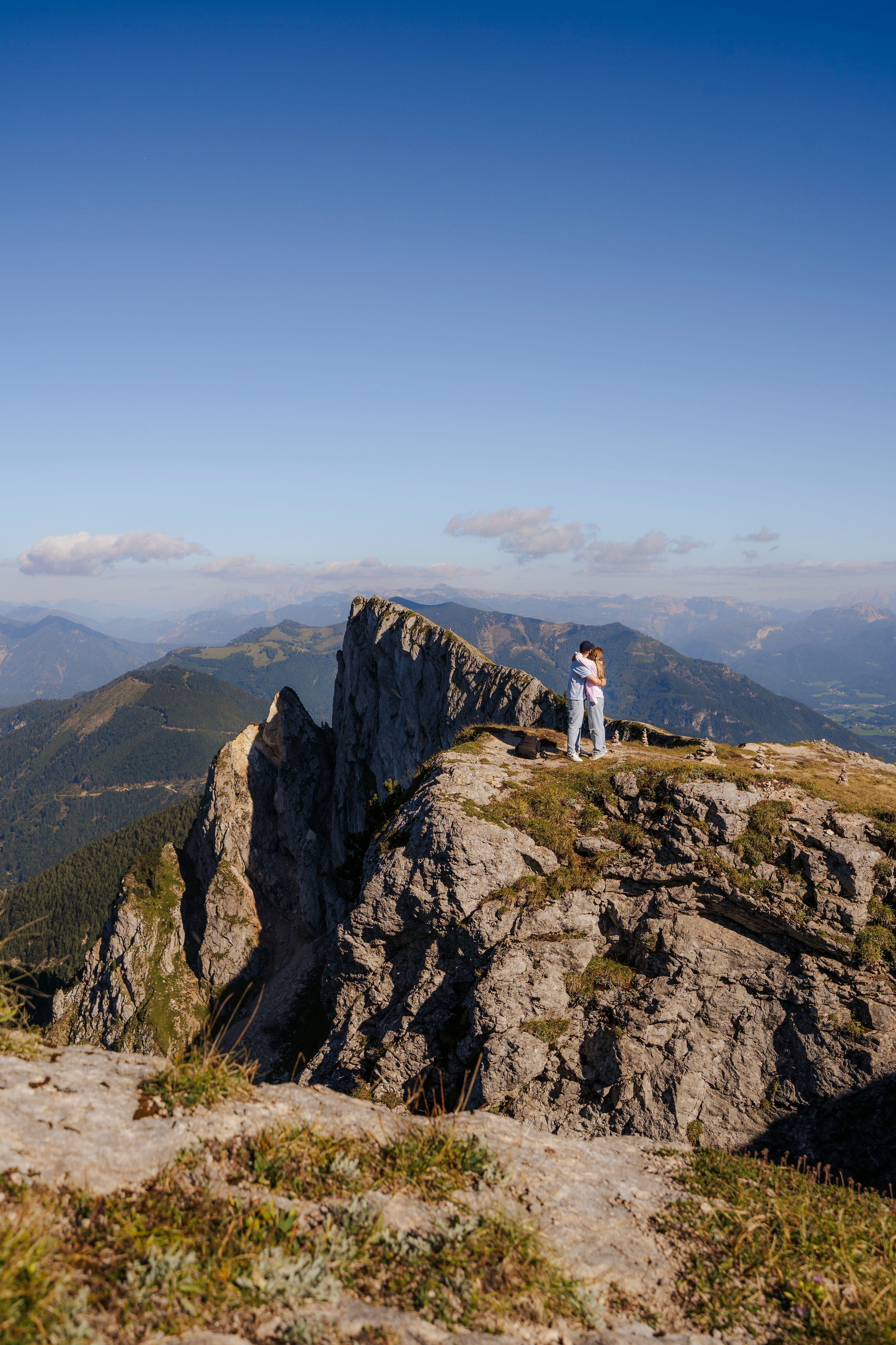 a couple standing on a mountain top
