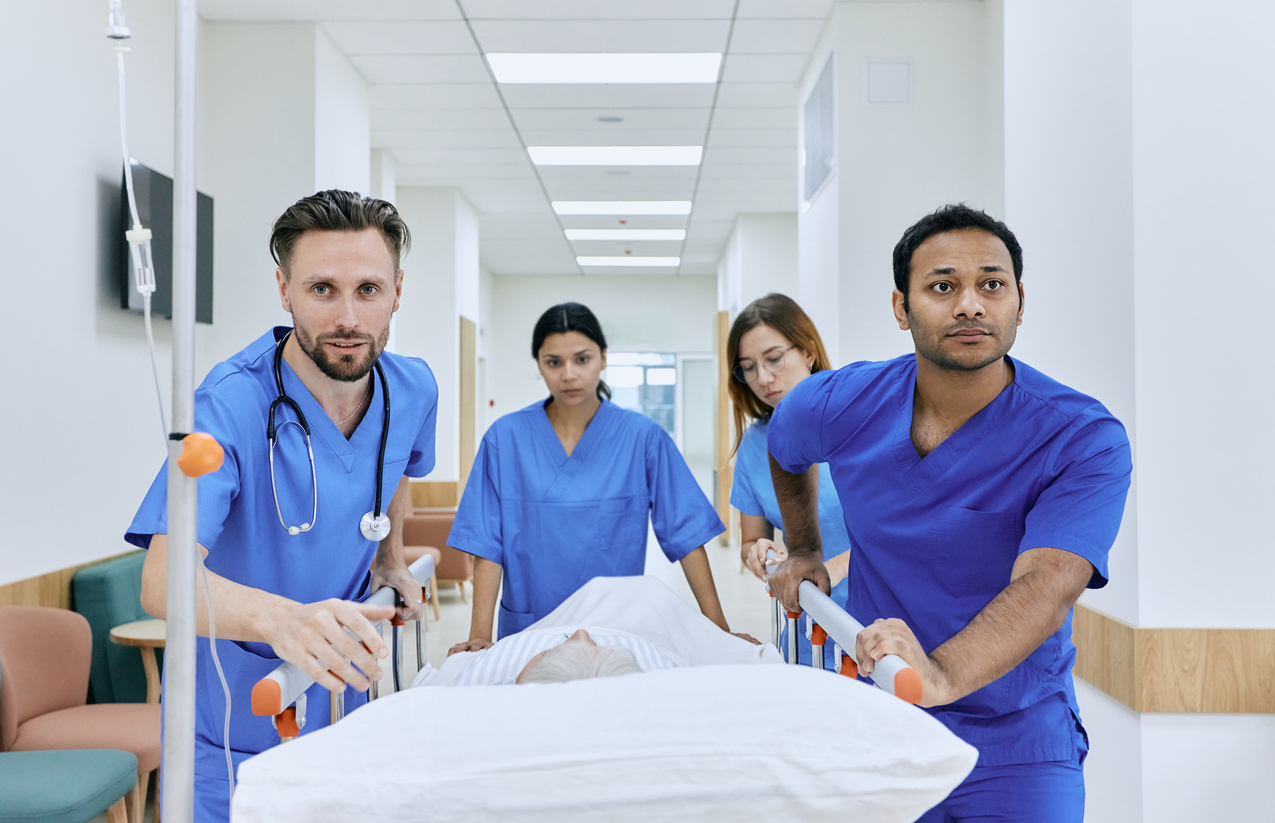 a group of people in blue scrubs pushing a patient on a stretcher