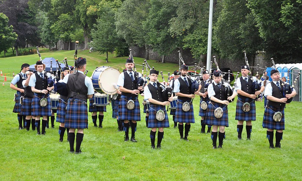 a group of people in kilts playing instruments