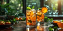 two glasses of ice tea with orange slices and mint leaves