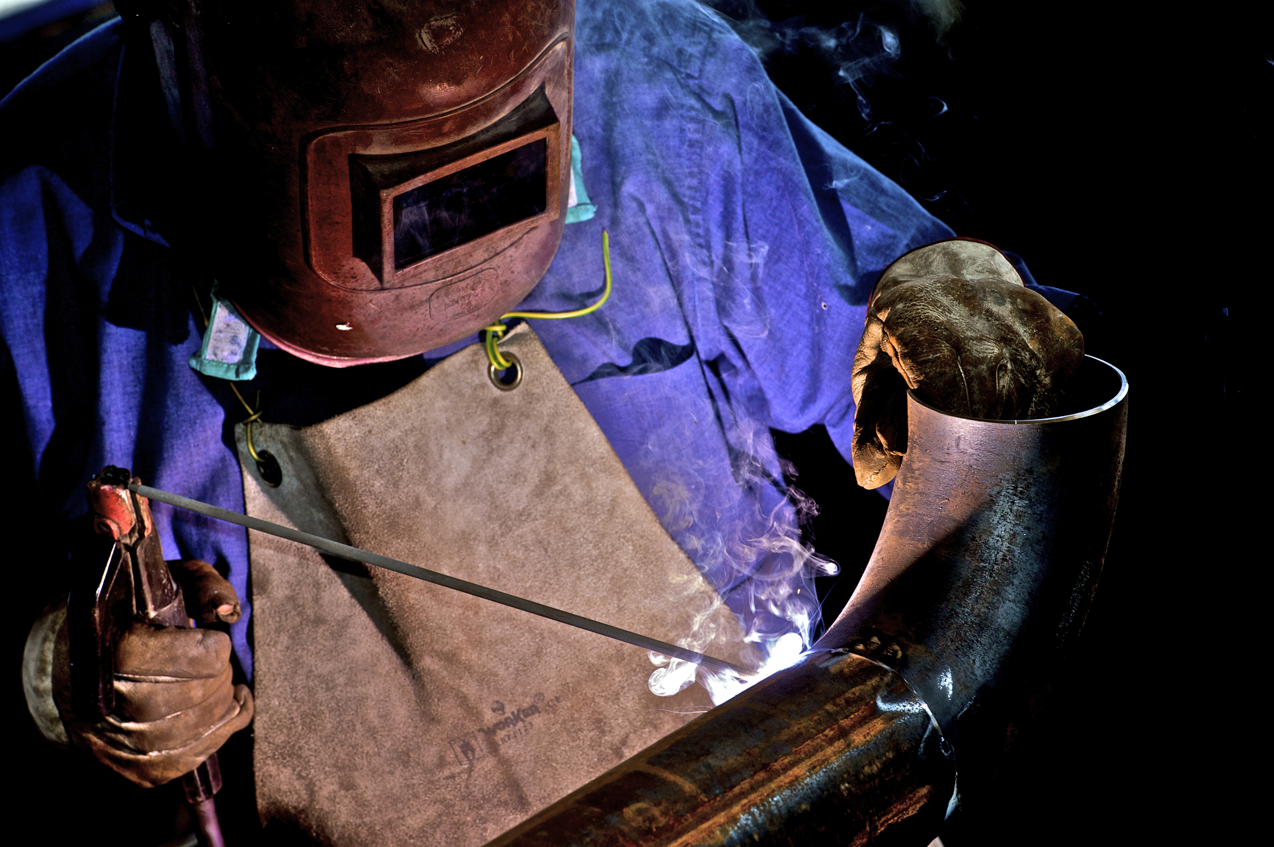 a person welding a pipe