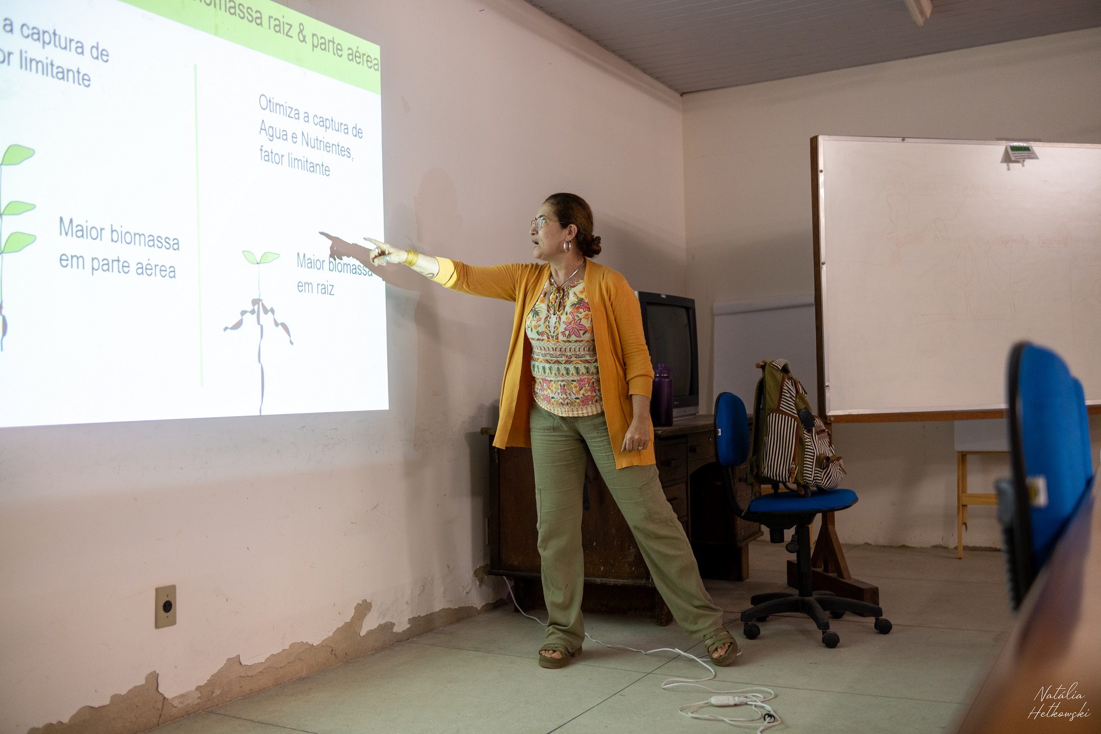 a woman pointing at a projector screen