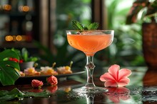 a glass of pink liquid with a flower on a table