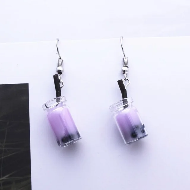 a pair of earrings with a jar of purple liquid