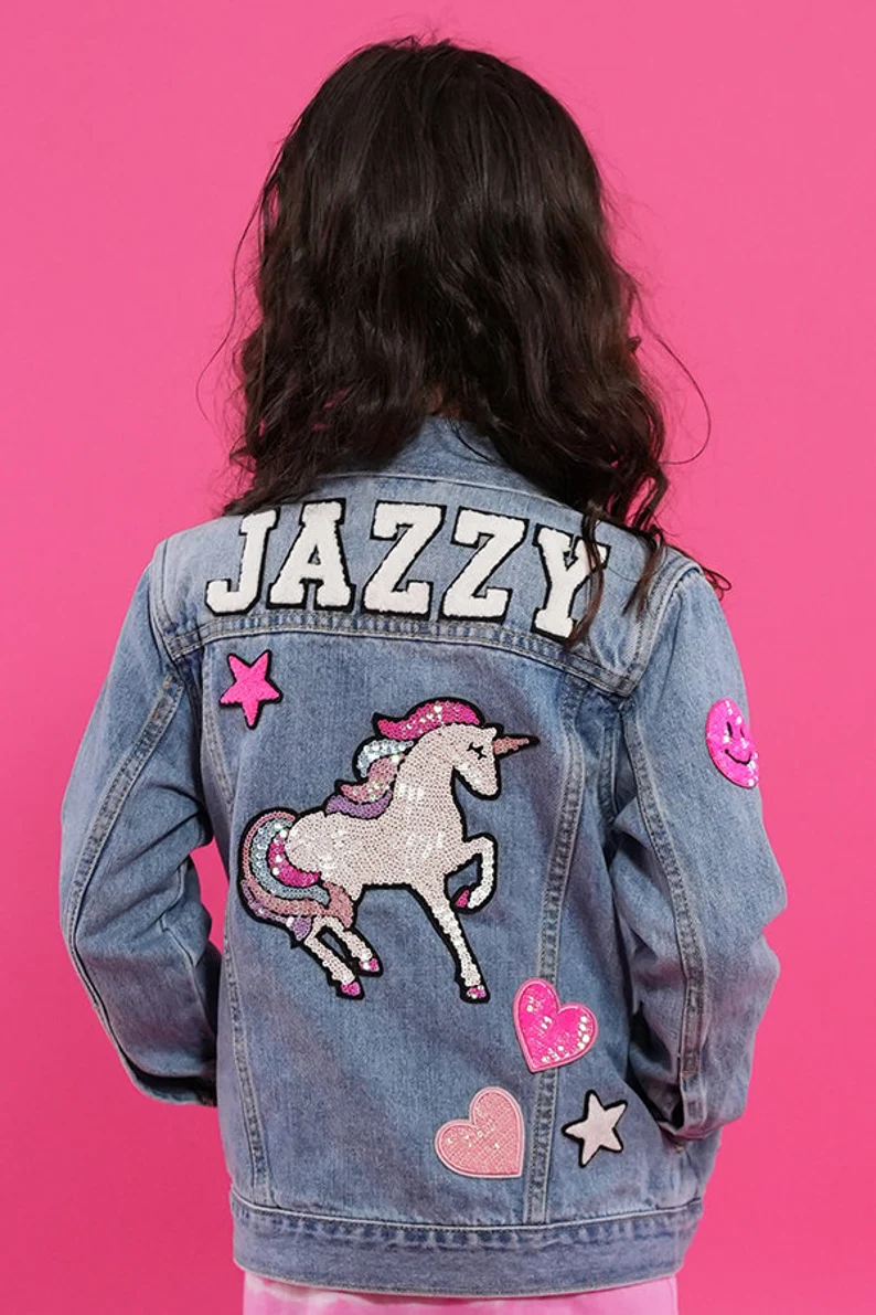 a person wearing a denim jacket with patches on it