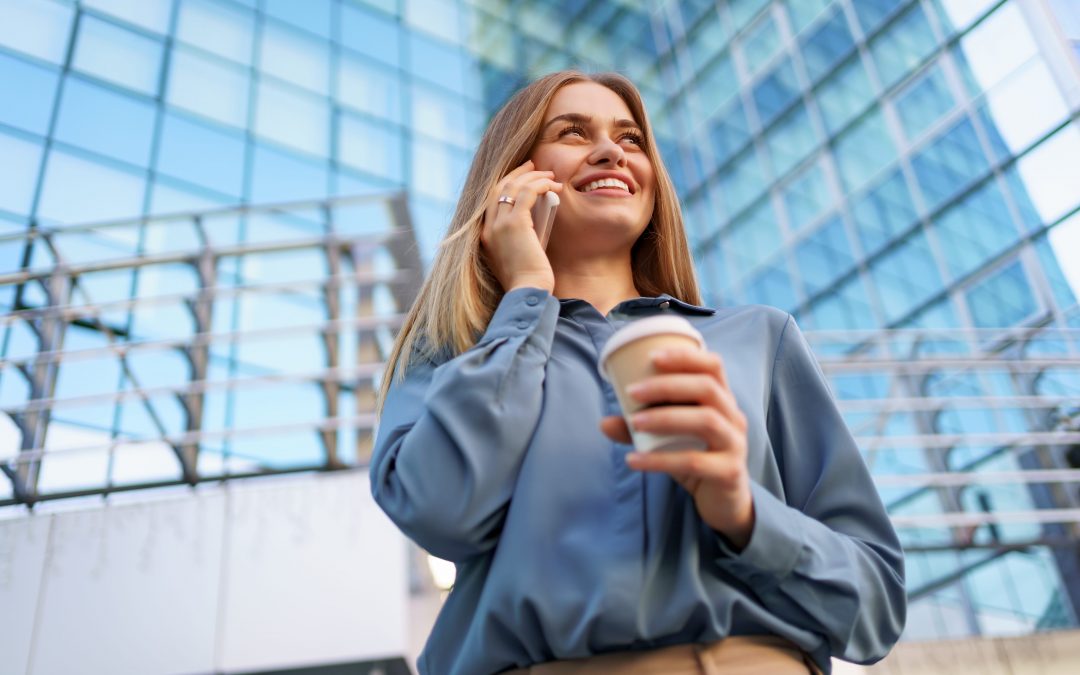 a woman holding a coffee and talking on a phone
