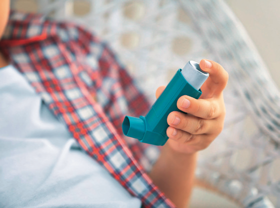 a person holding an asthma inhaler