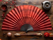 a red fan and teapot on a table