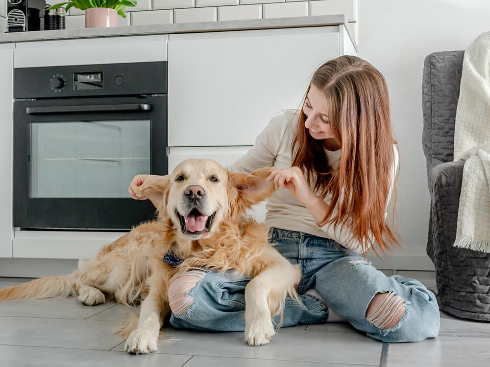 a woman sitting on the floor with a dog