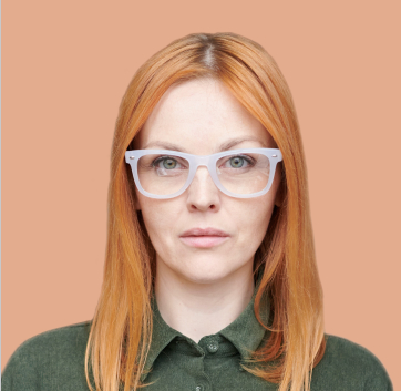 a woman with red hair wearing white glasses