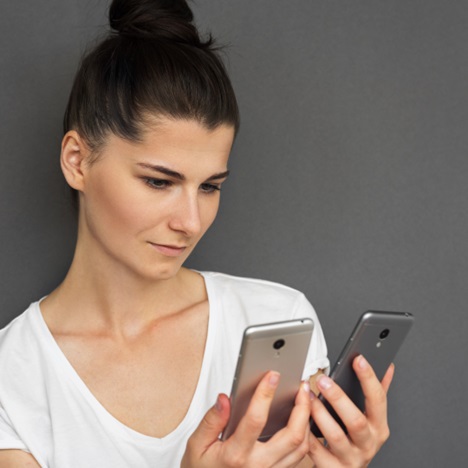 a woman holding two cell phones