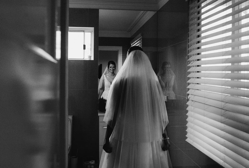 a bride looking at her reflection in a mirror