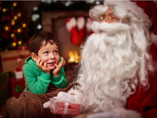 a child sitting on a chair with a santa claus
