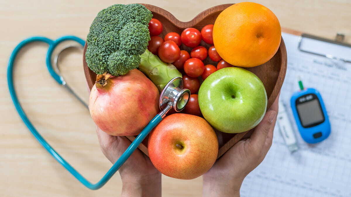 a heart shaped bowl of fruits and vegetables