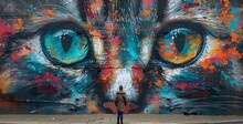 a person standing in front of a wall with a cat face painted on