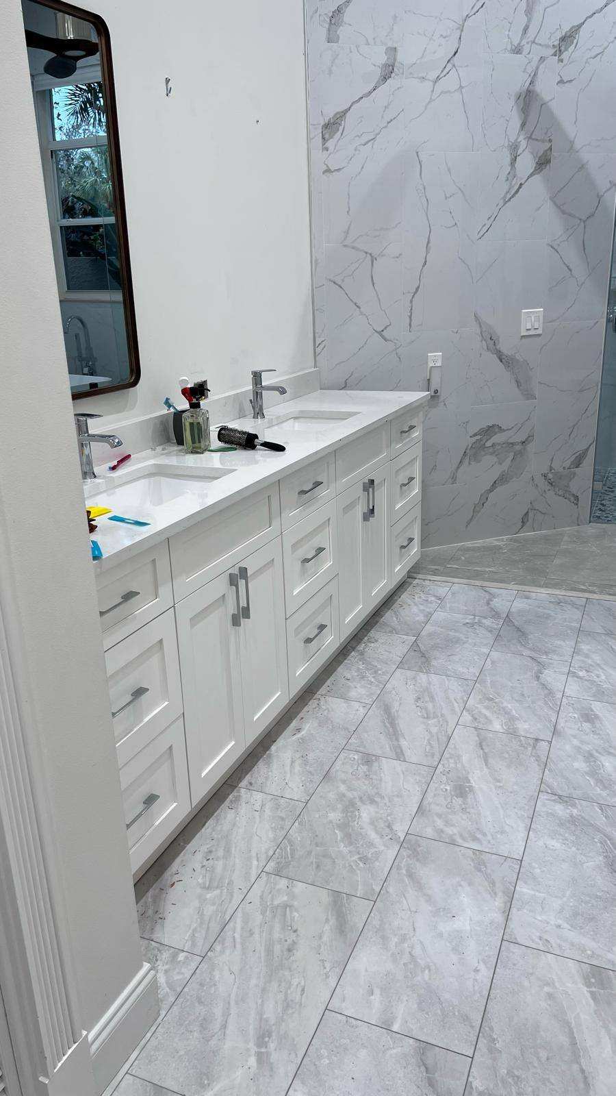 a bathroom with white cabinets and white tile floor