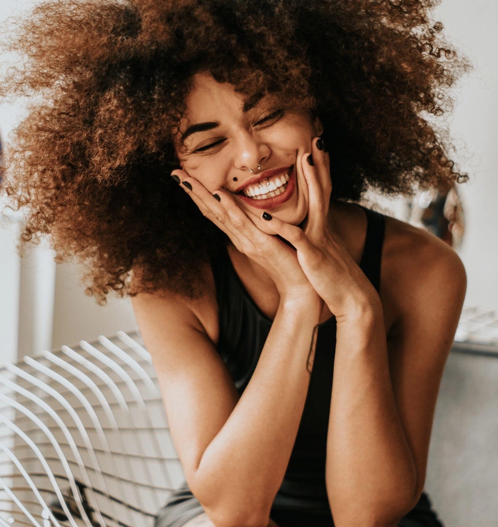 a woman with curly hair laughing