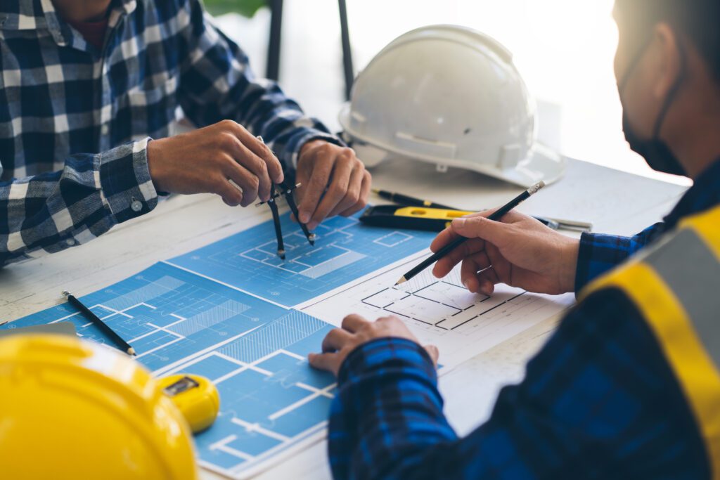 a pair of men looking at a blueprint