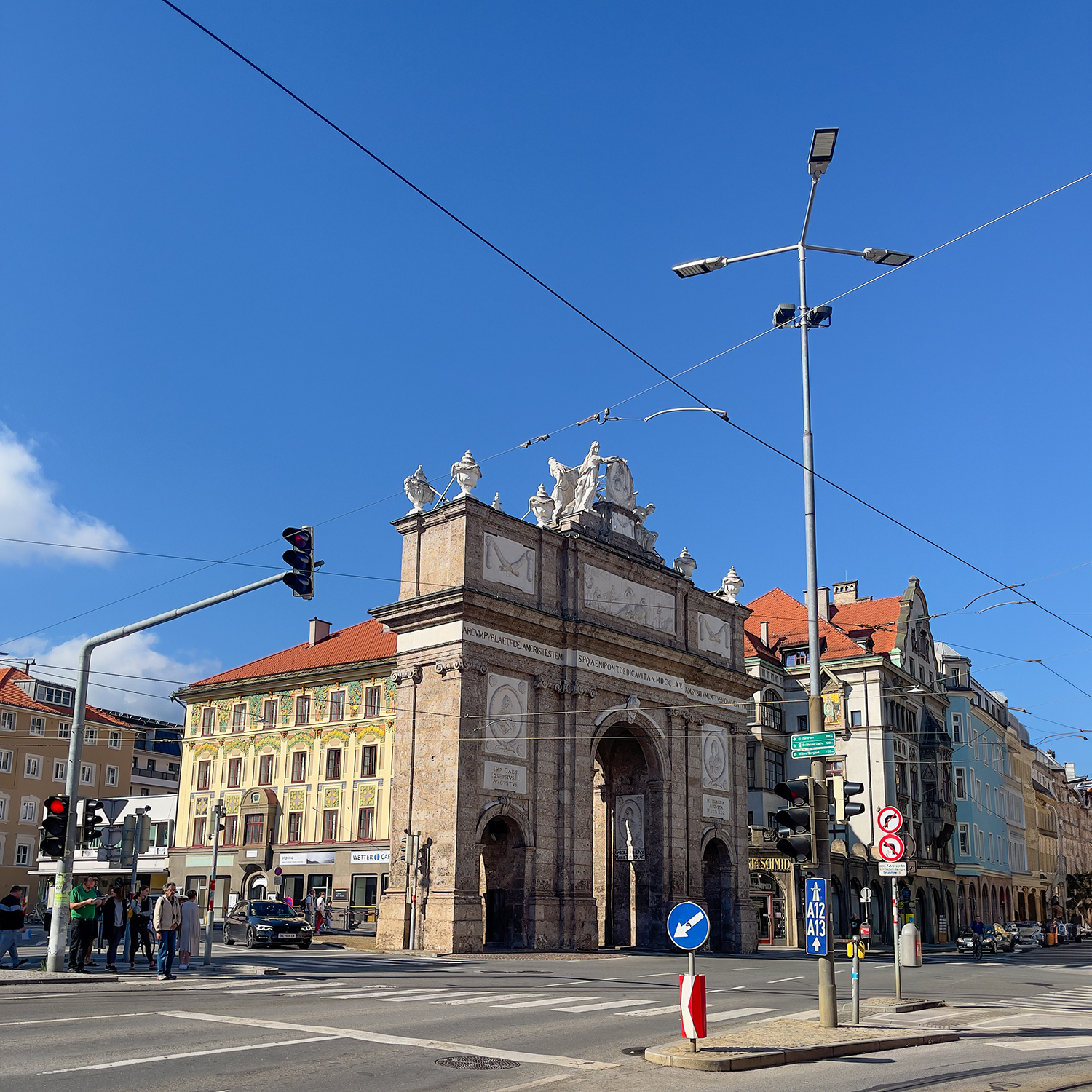 a large stone arch on a street corner