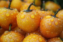 a group of yellow tomatoes with water droplets on them