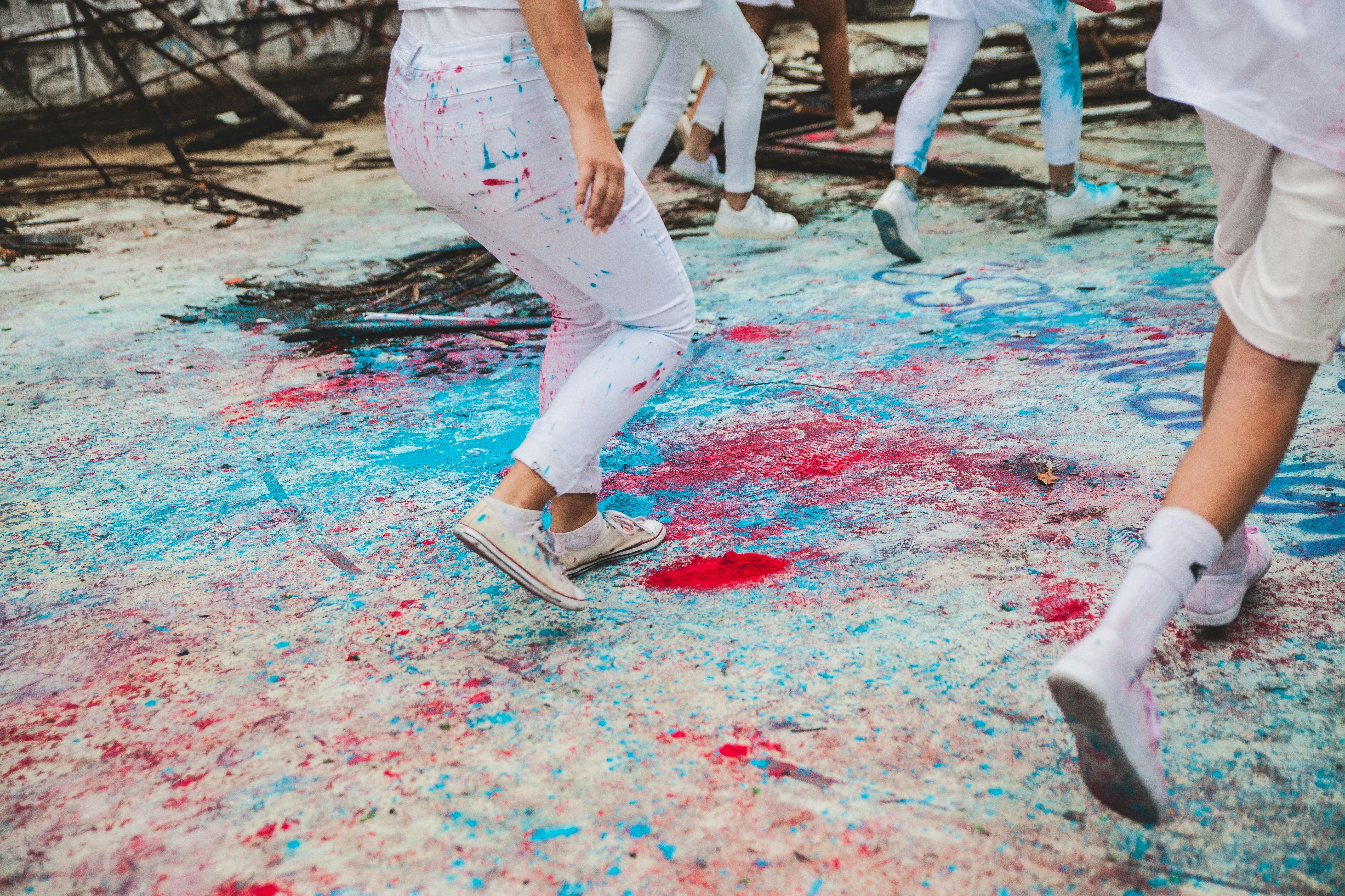 a group of people in white and red paint splattered on the ground